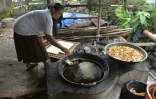 Une femme en train de frire du tofu dans le village de Kalisari, en Indonésie, le 31 mars 2016