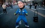 Une personne masquée défile dans la rue lors d'un rassemblement contre le président sud-coréen Yoon Suk Yeol, à Séoul, le 29 mars 2025