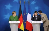 Le président français Emmanuel Macron, informé de la prise d'otages à Trèbes, pendant une conférence de presse avec la chancelière allemande Angela Merkel à Bruxelles le 23 mars 2018