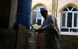 Un Afghan remplit d'eau des bouteilles en plastique au robinet d'une citerne, le 25 octobre 2018 à Kaboul
