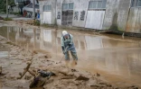 Un ouvrier dégage de la boue dans un lieu touché par un glissement de terrain à Wajima, au Japon, le 22 septembre 2024
