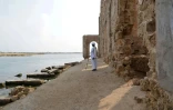 Un homme se tient face à la mer, devant une ruine dans le port soudanais de Suakin, le 22 janvier 2026
