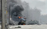 Un blindé en feu et le corps d'un soldat dans une rue de Kharkiv, seconde ville ukrainienne, le 27 février 2022
