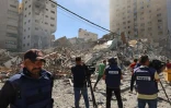 Des journalistes filment les décombres du bâtiment qui abritait les bureaux locaux de la chaîne qatarie Al-Jazeera et de l'agence internationale américaine Associated Press (AP) le 15 mai 2021 à Gaza