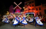 Des danseuses et danseurs devant le cabaret du Moulin Rouge lors de l'inauguration de ses nouvelles ailes, le 5 juillet 2024 Ă Paris