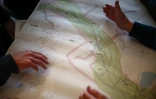 Des habitants regardent une carte de National Grid décrivant les plans proposés pour un nouveau tracé de pylônes électriques, à Ardleigh, dans l'est de l'Angleterre, le 27 janvier 2025
