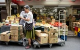 Une cliente achète des légumes sur un marché de Tokyo, le 17 août 2026