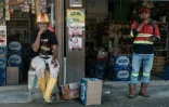 Des ouvriers devant des magasins près du parc industriel de Weda Bay, centre de traitement et de fusion du nickel, à Lelilef Sawai, dans le centre de l'île d'Halmahera, dans le nord des Moluques, le 18 avril 2025 en Indonésie