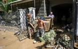 As floodwaters subsided, residents were left with the task of cleaning up the mud and destruction left behind
