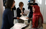 La journaliste et formatrice de l'ONG Femmes sans frontières (g) remet son diplôme à une élève tchéchène de l'"école des mères", à Vienne le 8 mars 2016