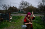 Olga Touss devant une maison endommagée par des bombardements dans le village de Mala Tokmachka, près du front, le 23 avril 2022d ans le sud de l'Ukraine 