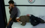 Deux garçons syriens blessés attendent d'être soignés dans un hôpital de fortune, après des raids aériens du régime sur la localité de Douma, dans le fief rebelle de la Ghouta orientale, le  23 février 2018 