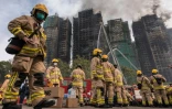 Des pompiers se préparent après qu'un important incendie a ravagé plusieurs immeubles d'appartements du complexe résidentiel Wang Fuk Court à Hong Kong, le 27 novembre 2025