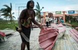 Une femme récupère des tôles pour reconstruire sa maison détruite par le cyclone Idai à Beira, au Mozambique le 21 mars 2019