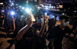 Des milliers de manifestants pro-démocratie unis dans une chaîne humaine brandissent leurs téléphones portables allumés à Hong Kong, le 23 août 2019