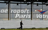 Un gendarme patrouille devant l'aéroport de Vatry, dans la Marne, le 23 décembre 2023, devant des bâches blanches installées sur les vitres du hall de l'aéroport où sont confinés plus de 300 Indiens