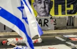 Un manifestant est allongé sur le sol, pour symboliser un otage israélien, lors d'une manifestation anti-gouvernementale organisée par les familles des Israéliens retenus en otages dans la bande de Gaza, le 23 août 2025