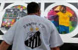 Un supporteur du club brésilien de football de Santos regarde une fresque dessinée par l'artiste brésilien Kobra représentant Pelé, à Santos au Brésil, le 21 octobre 2020