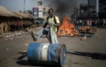 Un partisan de l'opposition au Zimbabwe pousse un bidon devant une barricade enflammée, le 1er août 2018 à Harare.