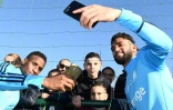 Bouna Sarr (g) et Jordan Amavi (d) prennent des selfies avec de jeunes supporters lors d'un entraînement à Robert-Louis Dreyfus, le 5 janvier 2018