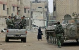 Des forces du régime syrien se dirigent vers la dernière enclave rebelle dans la Ghouta orientale, située autour de la ville de Douma. Photo prise le 28 mars 2018 à Hazzeh, une ville endommagée par les bombardements de l'armée syrienne