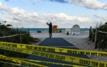 Un touriste franchit les barrières d'interdiction au plages de Miami Beach, le 19 mars 2020
