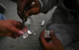 Un toxicomane se prépare une dose de speedball, mélange de cocaïne et d'héroïne, dans le centre de Medellin, en Colombie, le 1er mars 2022