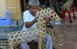 Fabrication d'un cheval en papier dans un atelier de Hanoï, le 8 août 2016