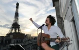 Le chanteur Adrien Pelon, dit Adril, joue sur son balcon pour ses voisins, à Paris le 2 mai 2020