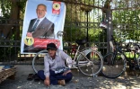 Un homme kurde assis dos à une affiche électorale à Erbil, capitale de la région autonome du Kurdistan irakien, à quelques semaines des élections parlementaires prévues le 12 mai
