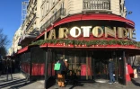 Des passants regardent l'entrée du restaurant La Rotonde à Paris, fermé après l'incendie survenu dans la nuit du 17 au 18 janvier 2020.