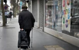 Un homme tire un chariot de courses dans les rues de Vincennes,