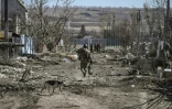 Un soldat ukrainien marche dans le village de Mala Rogan, à l'est de Kharkiv après sa reconquête par les forces ukrainiennes, le 28 mars 2022