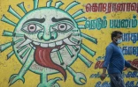 Un homme passe devant une peinture murale de sensibilisation au Covid-19 à Chennai en Inde le 16 décembre 2021