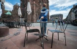 Un serveur du restaurant "La Maison Kammerzell" désinfecte une table avant la réouverture de l'établissement, le 30 mai 2020 à Strasbourg