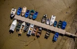 Des bateaux dans le lit asséché du lac des Brenets, à la frontière naturelle entre l'est de la France et l'ouest de la Suisse, le 18 juillet 2022
