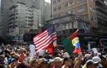 Un drapeau américain brandi par des partisans du chef de l'opposition vénézuélienne Juan Guaido qui se rassemblent le 12 février 2019 dans l'est de Caracas pour faire pression sur l'armée afin qu'elle laisse entrer l'aide humanitaire américaine