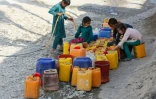 Des enfants remplissent des bidons d'eau potable à Jalalabad, le 8 novembre 2023 en Afghanistan