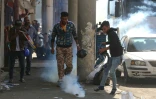 Des manifestants irakiens tentent d'éteindre des gaz lacrymogènes tirés par les forces de sécurité à Bagdad le 9 novembre 2019