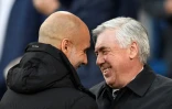 L'entraîneur espagnol de Manchester City Pep Guardiola salue son homologue italien du Real Madrid Carlo Ancelotti, avant la demi-finale aller de la Ligue des Champions, le 26 avril 2022 à l'Etihad Stadium