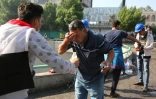 Des manifestants irakiens se rincent les yeux après des tirs de gaz lacrymogène à Bagdad, le 26 octobre 2016