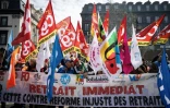 Mobilisation contre la réforme des retraites de manifestants brandissant des drapeaux de syndicats, le 28 mars 2023 à Clermont-Ferrand