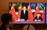 Sur l'image en visio-conférence, le Premier ministre chinois Li Keqiang (au centre) et son ministre du Commerce Zhong Shan (à droite) qui signe l'accord de libre-échange, le 15 novembre 2020