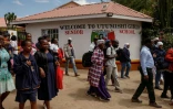 Des proches attendent devant l'école pour filles Utumishi où est survenu un incendie meurtrier, le 28 mai 2026 à Gilgil, au Kenya