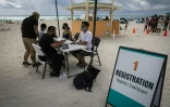 Des gens s'enregistrent pour se faire administer le vaccin Johnson & Johnson contre le Covid-19, dans un centre ouvert sur une plage Ă South Beach, en Floride, le 9 mai 2021