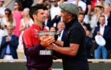 Le Serbe Novak Djokovic reçoit la coupe du vainqueur de Roland-Garros des mains de l'ancien champion français Yannick Noah le 11 juin 2023 à Paris