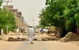 Un habitant de Bahri, en banlieue nord de Khartoum, marche au milieu des barricades erigées par des manifestants, le 9 juin 2019