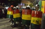 Des manifstants d'opposition se protègent avec des boucliers improvisés à La Paz le 8 novembre 2019