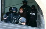 Le narcotrafiquant français  Mohamed Amra (C) est escorté par des policiers à la sortie de la Cour d'appel de Bucarest le 23 février 2025, un jour après son arrestation en vertu d'un mandat d'arrêt européen