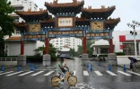 Un homme fait du vélo tout en s'abritant de la pluie à Pékin le 31 juillet 2023